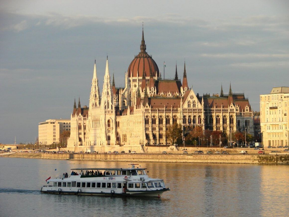 Un bateau de croisière naviguant sur le Danube au coucher du soleil.