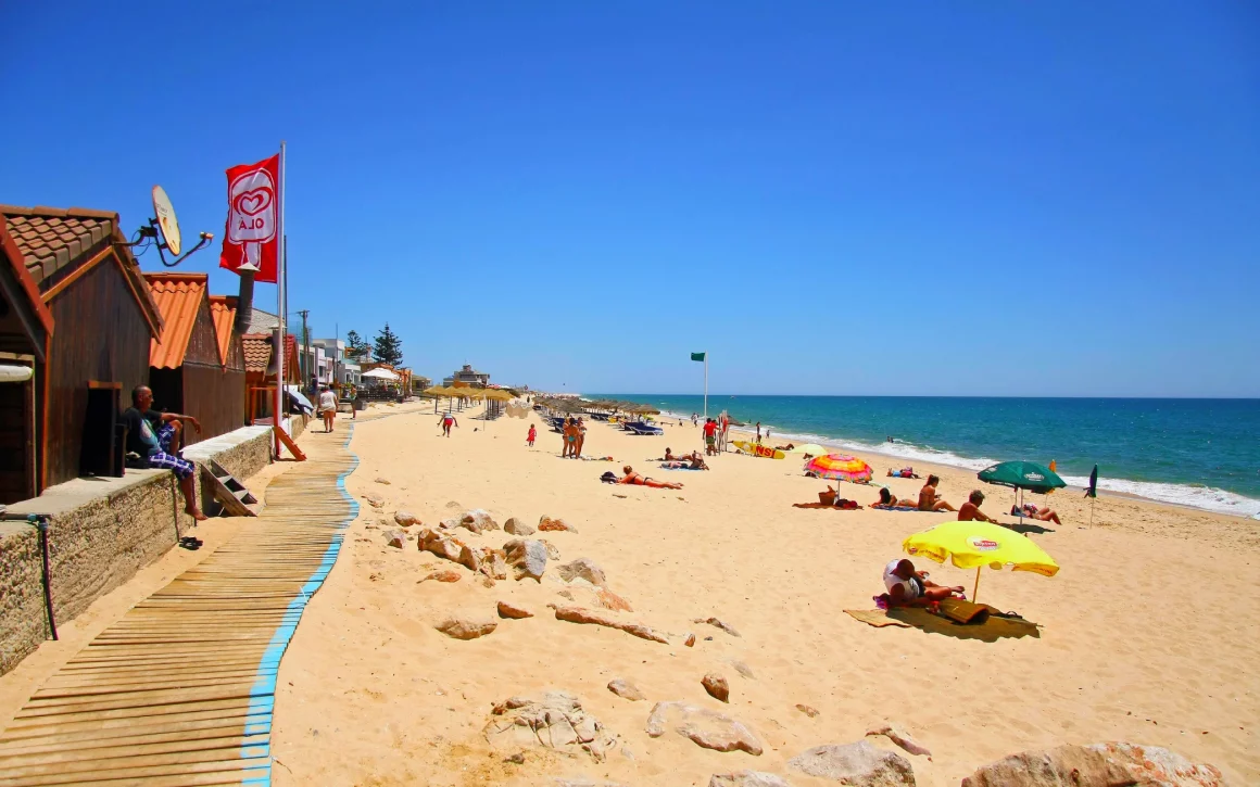 Praia de Faro longue plage de sable fin bordant l'océan Atlantique avec dunes et eaux bleues
