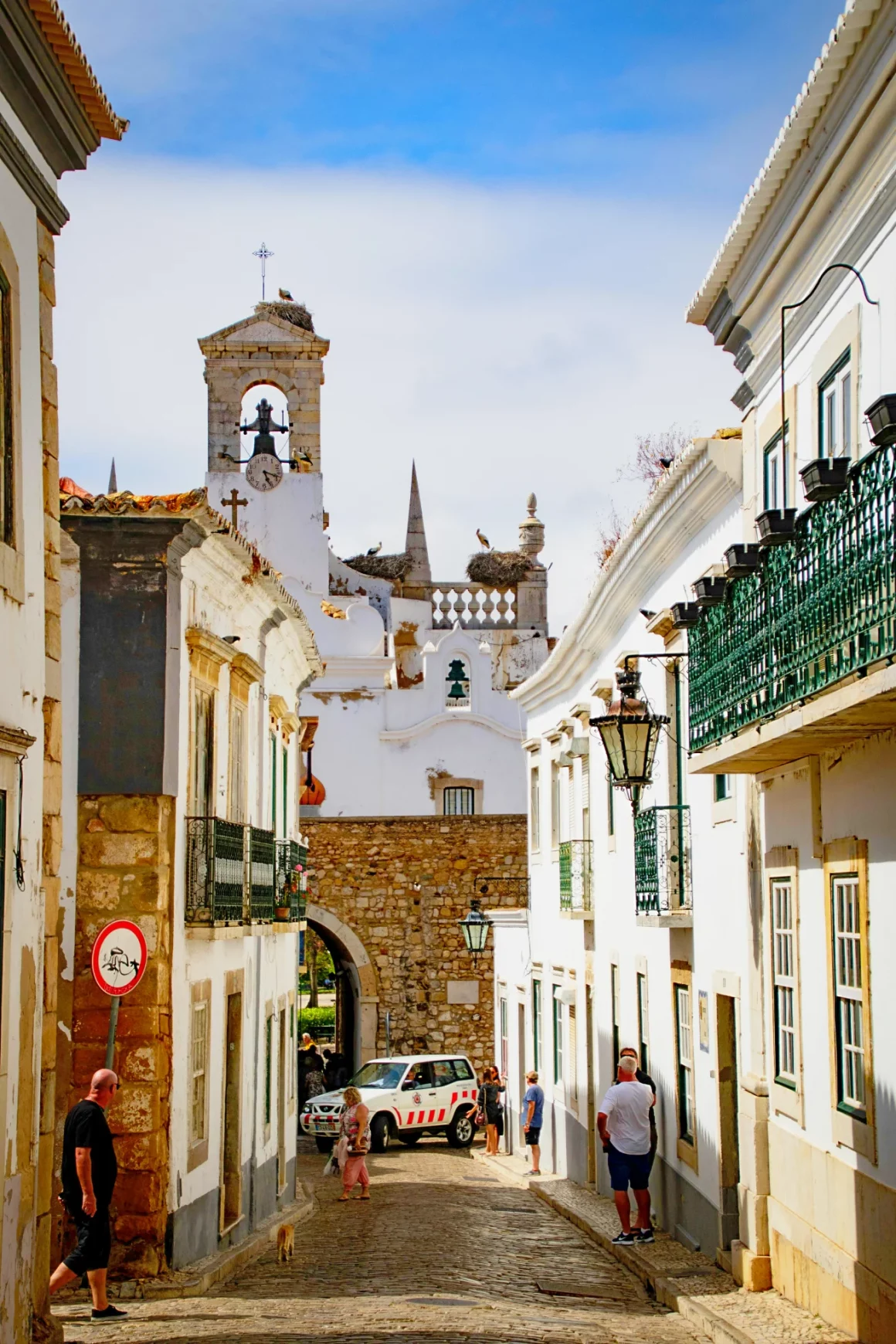 Ruelles pavées de la Cidade Velha de Faro avec maisons blanches aux volets colorés et orangers
