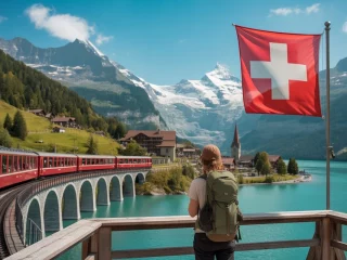 Train panoramique traversant les Alpes suisses avec vue sur les montagnes et un lac turquoise